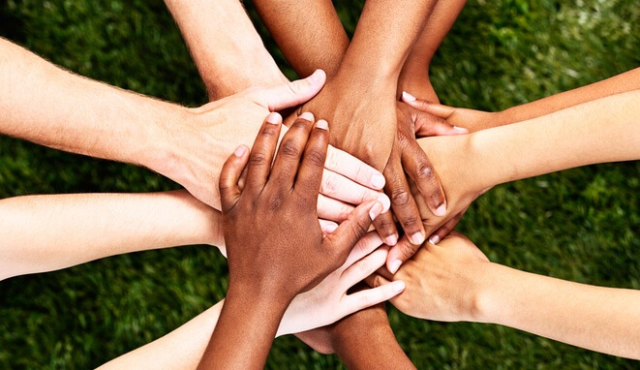 hands all coming together in a group in the middle